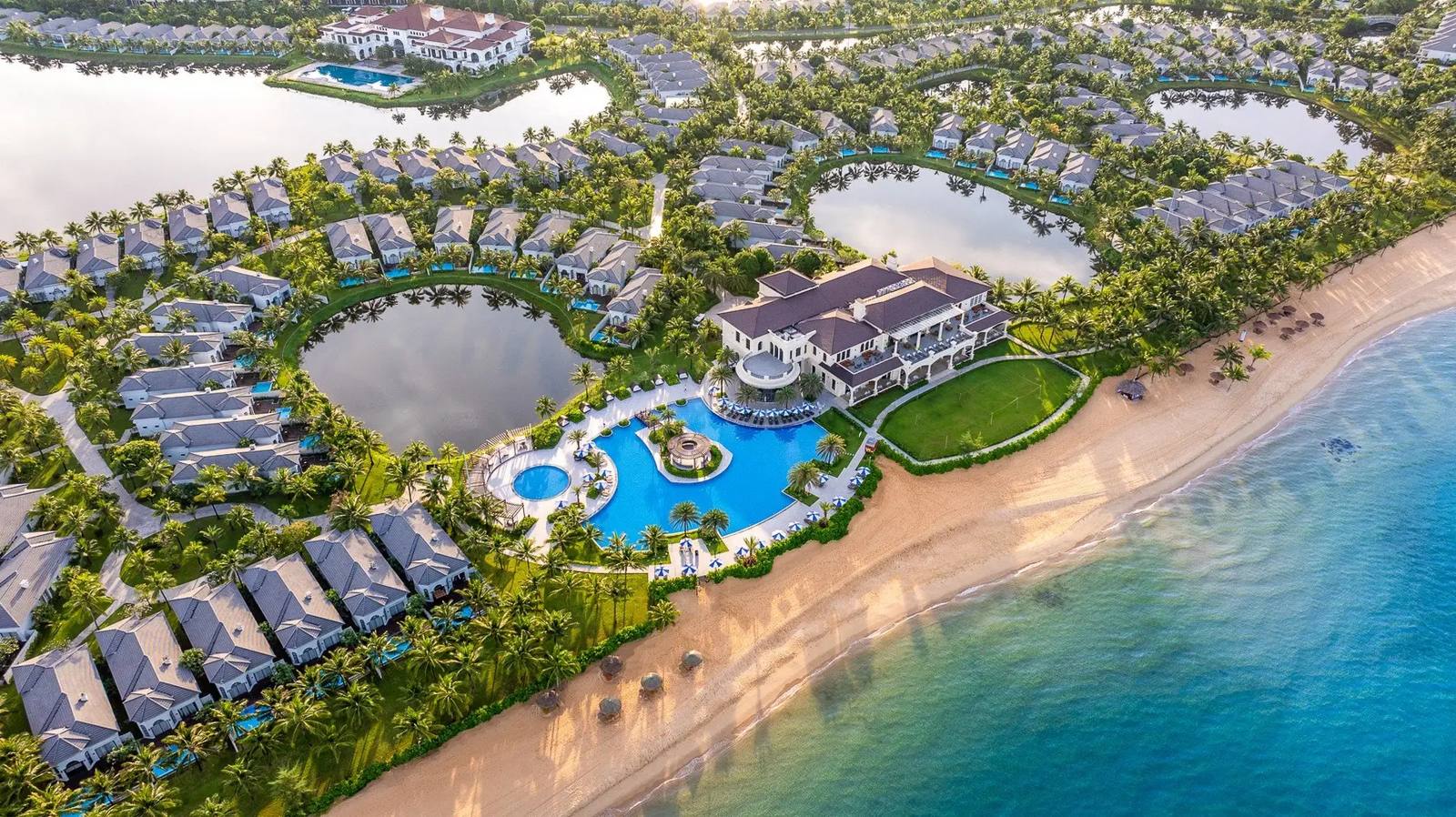 Légifotó a Meliá Vinpearl Phu Quoc resortról: villák pálmafák és tavak között, nagy medence és homokos tengerpart